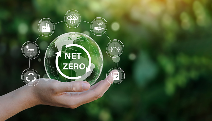 hand holding a globe with net zero text surrounded by sustainability icons representing renewable energy recycling and carbon neutrality focusing on 29 sustainable practices