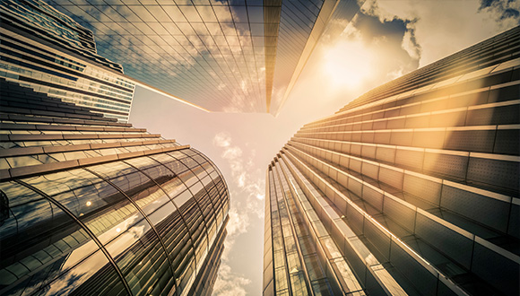 looking up at modern skyscrapers with glass facades reflecting sunlight against a blue sky capturing the essence of a vibrant city possibly featuring five distinct architectural styles