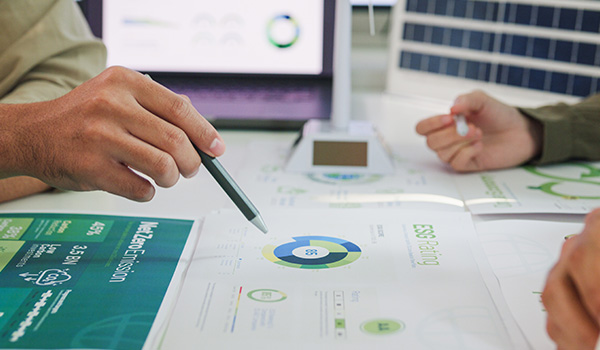hands discussing reports with charts and graphs indicating sustainability scores and environmental data analysis 7 key metrics for assessment
